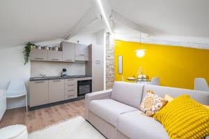 布雷西亚Cascina Conicchio - Metro Station - by Host4U的带沙发和黄色墙的客厅