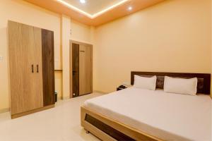 巴特那OYO Hotel Ambika Palace的一间卧室配有一张大床和一个木制橱柜