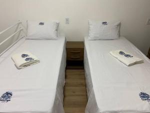 约恩维利Loft no Espinheiros - Joinville/SC的两张睡床彼此相邻,位于一个房间里