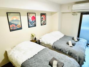 横滨Apartment hotel Hana in Yokohama的墙上有两张照片的房间的床铺