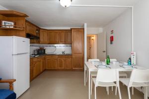 阿尔布费拉TAC - Fisherman's Beach Apartment的厨房配有桌椅和白色冰箱。