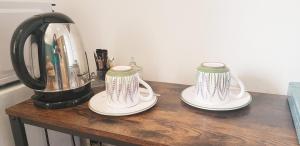 穆斯捷-圣玛丽"Les Lauriers" chambre d'hôtes indépendante avec terrasse privée的木桌上的两个茶壶,配有搅拌机