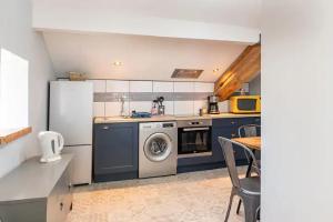 Saint-Martin-de-Seignanx莱斯埃库瑞杜塞克住宿加早餐旅馆的厨房配有冰箱和洗衣机。