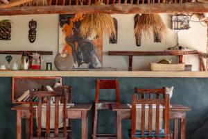 江比阿Pili Pili Oasis的一间酒吧,房间内设有木桌和椅子