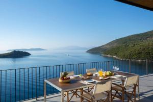 塞沃塔Villa Kalamos - Modern Villa in Sivota Bay with Direct Access to Sea的海景阳台上的桌子