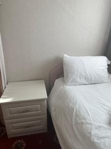 兰迪德诺Bella Vista的一张带白色枕头和床头柜的床