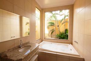 阿拉拉夸拉Motel Haraam的带浴缸、水槽和窗户的浴室