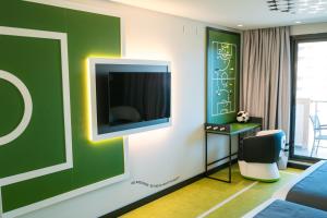 奥罗佩萨德尔马Hotel Magic Sports 4的一间房间,墙上配有电视和椅子