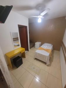 圣保罗豪斯佩达利亚伊皮兰加旅馆的小房间设有两张床和一张黄色的桌子