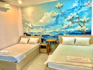 永隆Hotel Phước Thịnh的一间设有两张床的客房,并装饰有鲜花