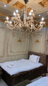 普里什蒂纳Hotel Premium的一间卧室配有一张带吊灯的大床