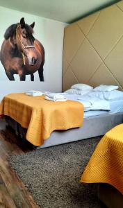 尼赖吉哈佐卡巴鲁斯洛瓦斯马约尔住宿加早餐旅馆的卧室配有一张床铺,墙上挂着一幅马的照片