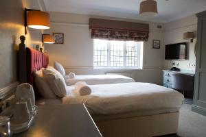阿什顿下安林恩The Broadoak的酒店客房设有两张床和一张桌子。