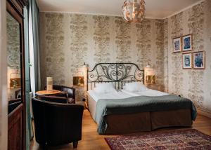 韦斯特维克帕克酒店的一间卧室配有一张床、一把椅子和一个吊灯。