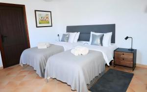 EsteponaLa Pina Verde的一间卧室配有两张带白色床单的床