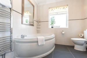 南安普敦Douglas House的白色的浴室设有浴缸和卫生间。