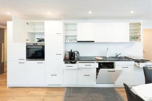 埃申茨Exklusive 2,5 Zimmer Wohnung的白色的厨房配有白色橱柜和电器