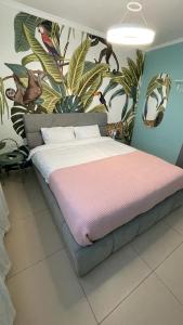 海法Carmel Beach Luxury Apartment的卧室配有一张大床,墙上挂有绘画作品