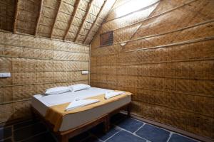 亨比Hampi Social Resort的小房间,砖墙里设有一张床铺