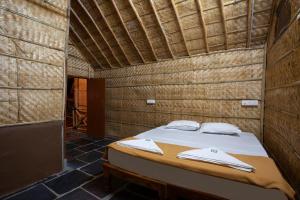 亨比Hampi Social Resort的木制客房内的一间卧室,配有一张床
