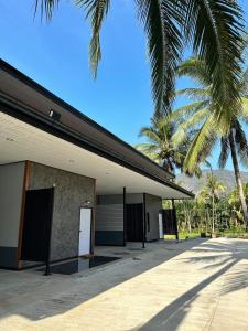 攀牙Phangnga Save House - เซฟเฮาส์พังงา的一座有白色门和棕榈树的建筑