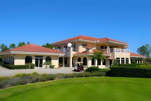 海恩斯城Quiet house with pool on a Top golf course的车道上带高尔夫球车的大房子