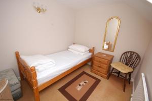 谢林汉姆Romany Rye的一间卧室配有一张床、镜子和椅子