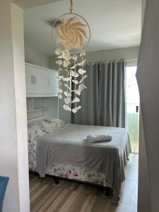 嘎林海斯港Studio A completo 400m da praia的一间卧室配有一张床和一个吊灯