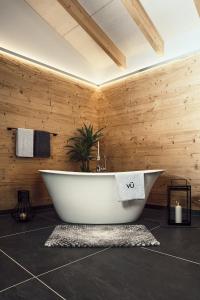 明希贝格VÜ Terrassen-Chalets的木墙客房内的浴缸