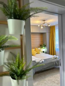 戈韦达尔齐Bulgarane House的一间卧室配有一张带黄色枕头和植物的床