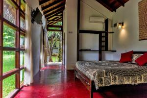 锡吉里亚Sat Nam Village Eco-Hotel的一间设有床铺的卧室,位于带窗户的房间内