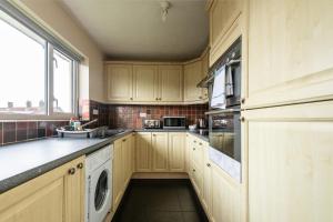 Hale3 Bed Apartment - Perfect for Contractors near Liverpool Airport的厨房配有木制橱柜、洗衣机和烘干机