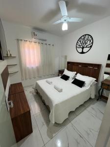 布罗塔斯Vila Pepira ViP的一间卧室配有一张床和吊扇