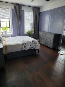 布鲁克林Brooklyn Flat Tropical Vibe的一间卧室配有一张床、一个梳妆台和一扇窗户。