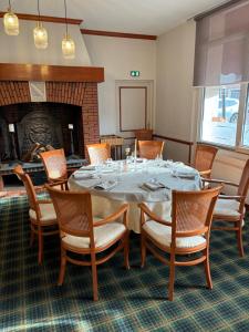 普瓦红衣主教餐厅酒店的一间带桌椅和壁炉的用餐室