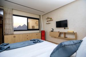 开罗Piccolo Mondo Boutique Hotel的一间卧室设有一张带窗户的床和一台电视。