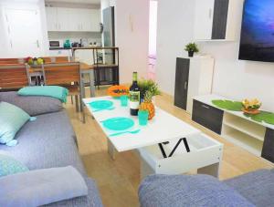圣伊西德罗Vacaciones Sur Tenerife Ofogar的客厅配有沙发和一张桌子及一瓶葡萄酒
