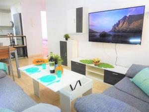 圣伊西德罗Vacaciones Sur Tenerife Ofogar的客厅配有沙发和墙上的电视