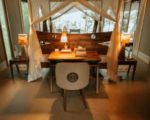 SekenaniSoroi Luxury Migration Camp的带窗户的客房内的桌椅