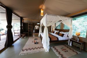 SekenaniSoroi Luxury Migration Camp的一间卧室配有一张带天蓬的床