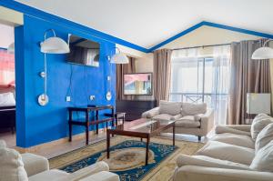 班布里Sai Rock Beach Hotel & Spa的客厅拥有蓝色的墙壁和白色的家具