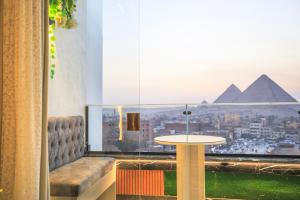 开罗Piccolo Mondo Boutique Hotel的一间设有桌子并享有金字塔景色的客房