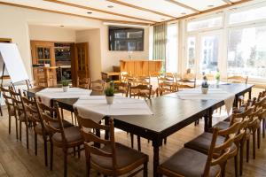 林根科尔平豪斯酒店-餐厅的大型用餐室配有桌椅