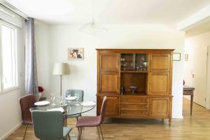 波尔多Queyries - Appartement 2 chambres avec Parking的一间带桌子和木柜的用餐室