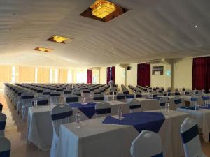 班布里Sai Rock Beach Hotel & Spa的一个带白色桌椅的大型宴会厅