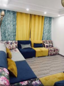 InezganeAppartement moyen standing的客厅配有蓝色和黄色的家具和黄色的窗帘