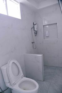 沙美岛Samed Seaside Resort - เสม็ด ซีไซด์ รีสอร์ท的白色的浴室设有卫生间和淋浴。