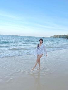 沙美岛Samed Seaside Resort - เสม็ด ซีไซด์ รีสอร์ท的站在海滩上水面上的女人