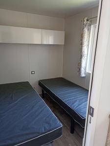 乌伊斯特勒昂Riva Bella chez Caraphou的小房间设有两张床和窗户