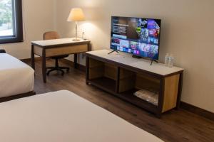 莫雷利亚莫雷利亚图罗特尔酒店的客房设有一张桌子和一台平面电视
